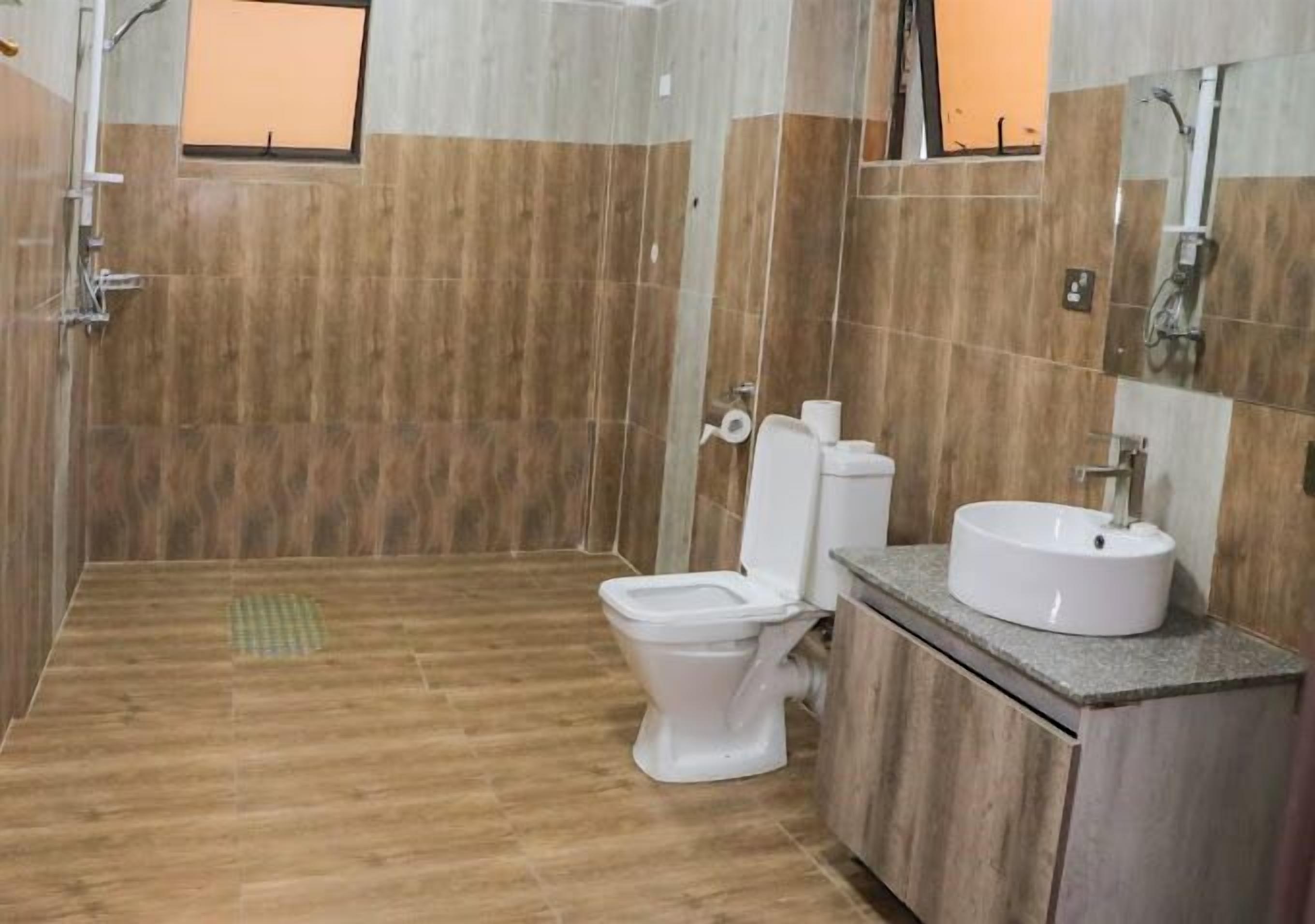 Un baño con inodoro, lavamanos y zona de ducha.