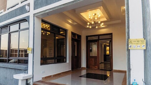 A hotel entrance with a modern design, featuring a glass door, a tiled floor, and a chandelier. - Grand Tiara Hotel Naivasha (Naivasha)