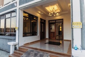A hotel entrance with a modern design, featuring a glass door, a tiled floor, and a chandelier. - Grand Tiara Hotel Naivasha (Naivasha)