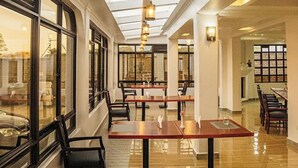 A spacious restaurant with high ceilings, large windows, and a polished floor. Tables and chairs are neatly arranged. - Grand Tiara Hotel Naivasha (Naivasha)