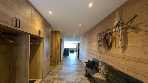 A hallway with wooden walls and a bench.