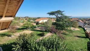 A residential area with a clear view of houses, a large tree, and a well-maintained lawn.