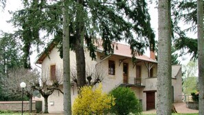 A two-story house with a balcony, surrounded by trees and a small garden. - Family cottage in the heart of Côte Roannaise - Pets allowed (Saint-André-d'Apchon)