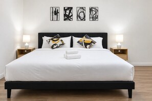 A bed with a black frame, white bedding, and two bedside lamps. - Spacious 2BR Near NRG | w/ Pool, Patio, BBQ & GYM (Houston)