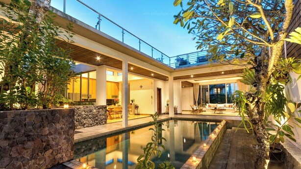 Un espace piscine extérieur moderne, agrémenté d’un mur en pierre, d’une terrasse en bois et de plantes en pot.