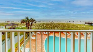A pool area with a view of the beach and ocean. - Seacrest 202 | Gulf-Front Condo w/ Balcony (Gulf Shores)
