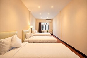 A hotel room with two beds, a window, an air conditioning unit, and a lamp. - House in Khao San - OH Homes Samsen 12 (Bangkok)
