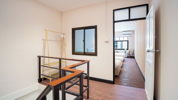 A hallway with a wooden staircase, a window, and a door leading to another room. - House in Khao San - OH Homes Samsen 12 (Bangkok)