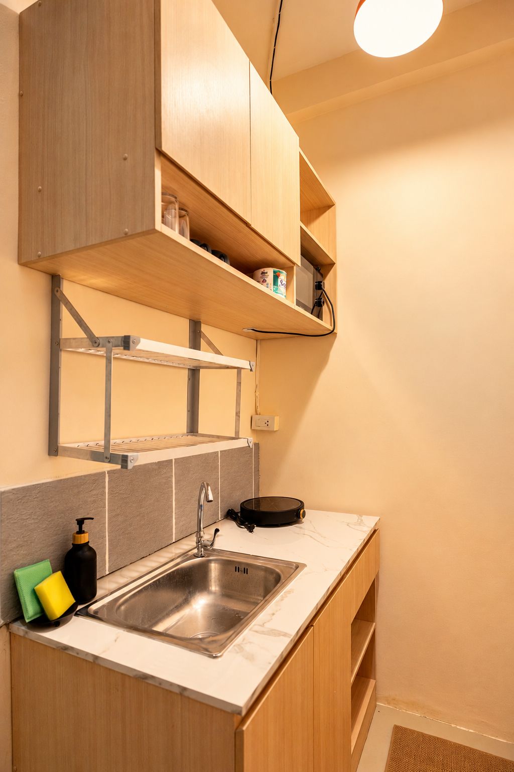 A compact kitchen with a built-in sink, wooden cabinets, and a countertop.