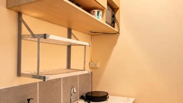 A compact kitchen with a built-in sink, wooden cabinets, and a countertop.