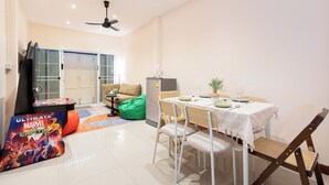A dining area with a table set for two, a ceiling fan, and a green bean bag chair. - House in Khao San - OH Homes Samsen 12 (Bangkok)