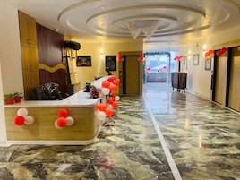 A reception area with a marble floor, a reception desk, and a wall-mounted wooden panel.