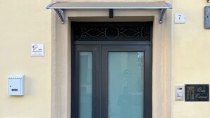 A black door with a glass panel, a security camera, a mailbox, and a plaque reading "Casa Cavour". - Cavour House Lentini (Lentini)