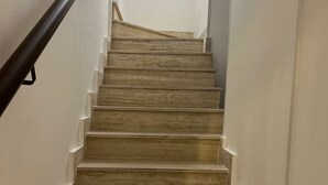 A staircase with wooden steps and a metal handrail, leading upwards. - Cavour House Lentini (Lentini)