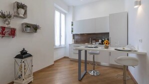 A modern kitchen with white cabinets, a central island, and bar stools. - Ultramarine neptune (Nettuno)