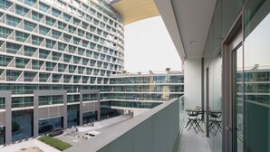 A modern building with a glass facade, a rooftop terrace with seating, and a clear view of the surrounding area.