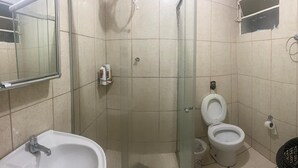 A small bathroom with a shower, a toilet, and a sink.