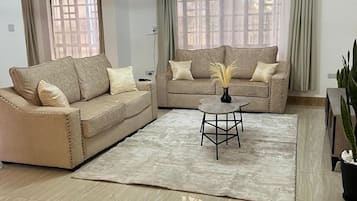 Deluxe-Apartment, Gartenblick | Wohnbereich | 32-Zoll-Smart-TV mit Digitalempfang