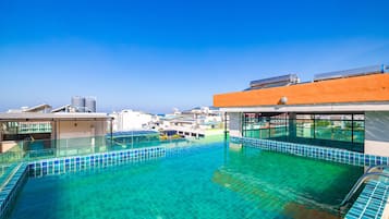 Een buitenzwembad, parasols voor strand/zwembad