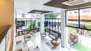 A spacious indoor area with large windows, comfortable seating, and a view of the outside. - Phuket Patong Buri Resort (Patong)