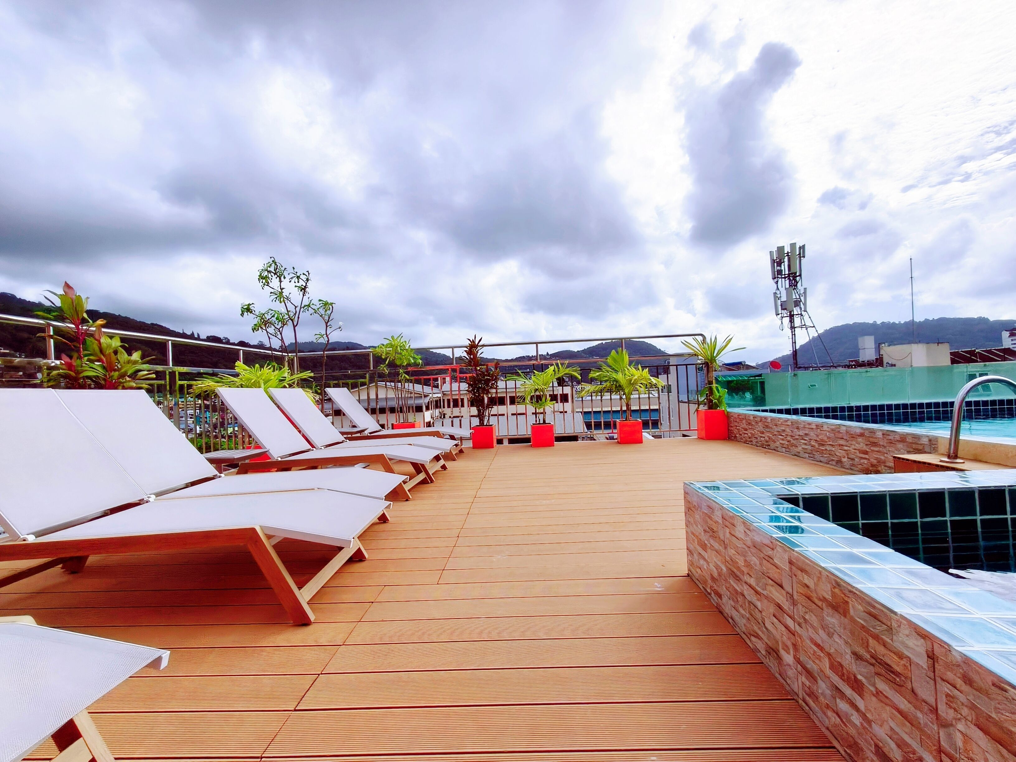A rooftop lounge area with sun loungers and a swimming pool.