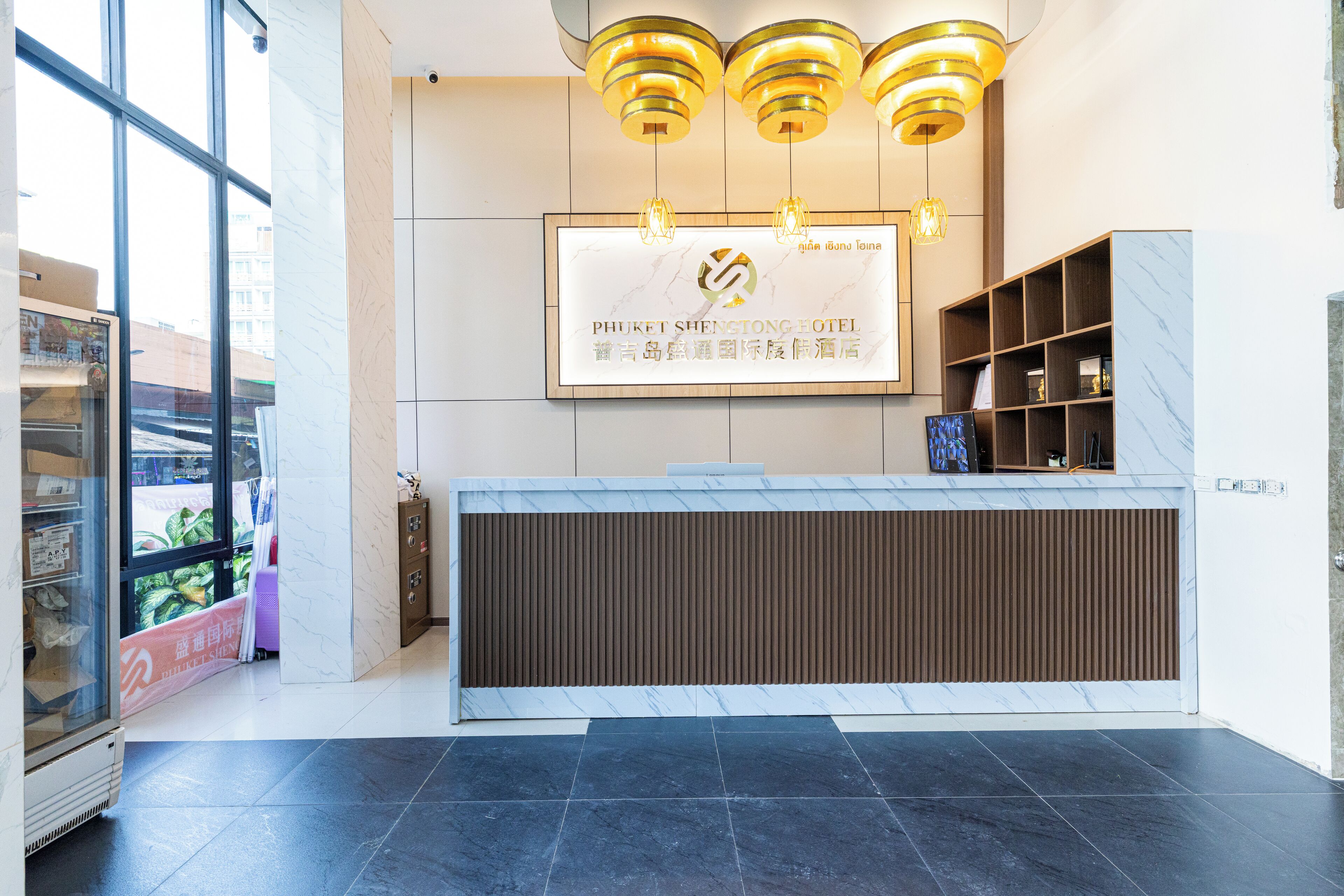 A modern hotel reception area with a marble reception desk, a large framed sign, and a wooden panel wall.
