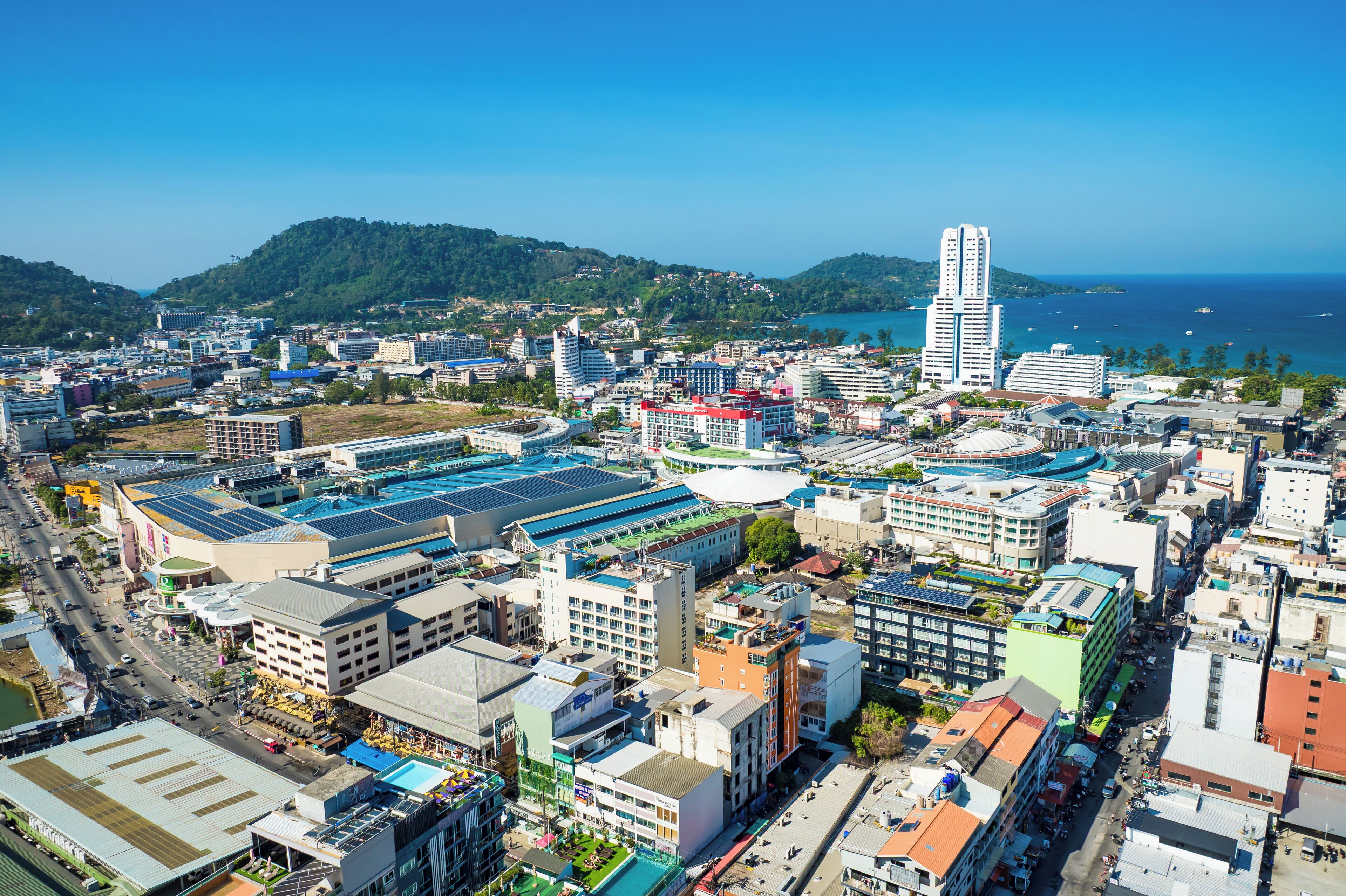 A cityscape with a prominent tall building, various commercial buildings, and a coastline.