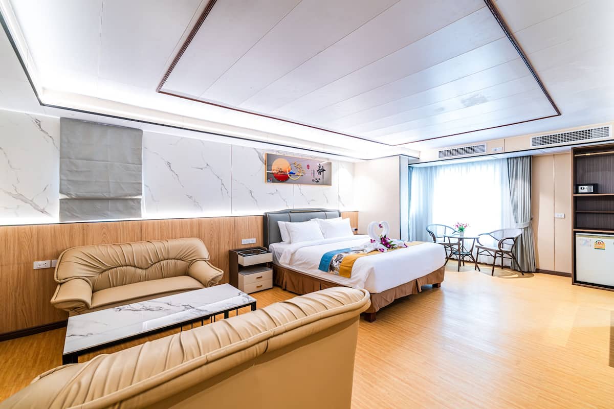 Une chambre d’hôtel moderne équipée d’un lit, d’un canapé et d’un coin repas.