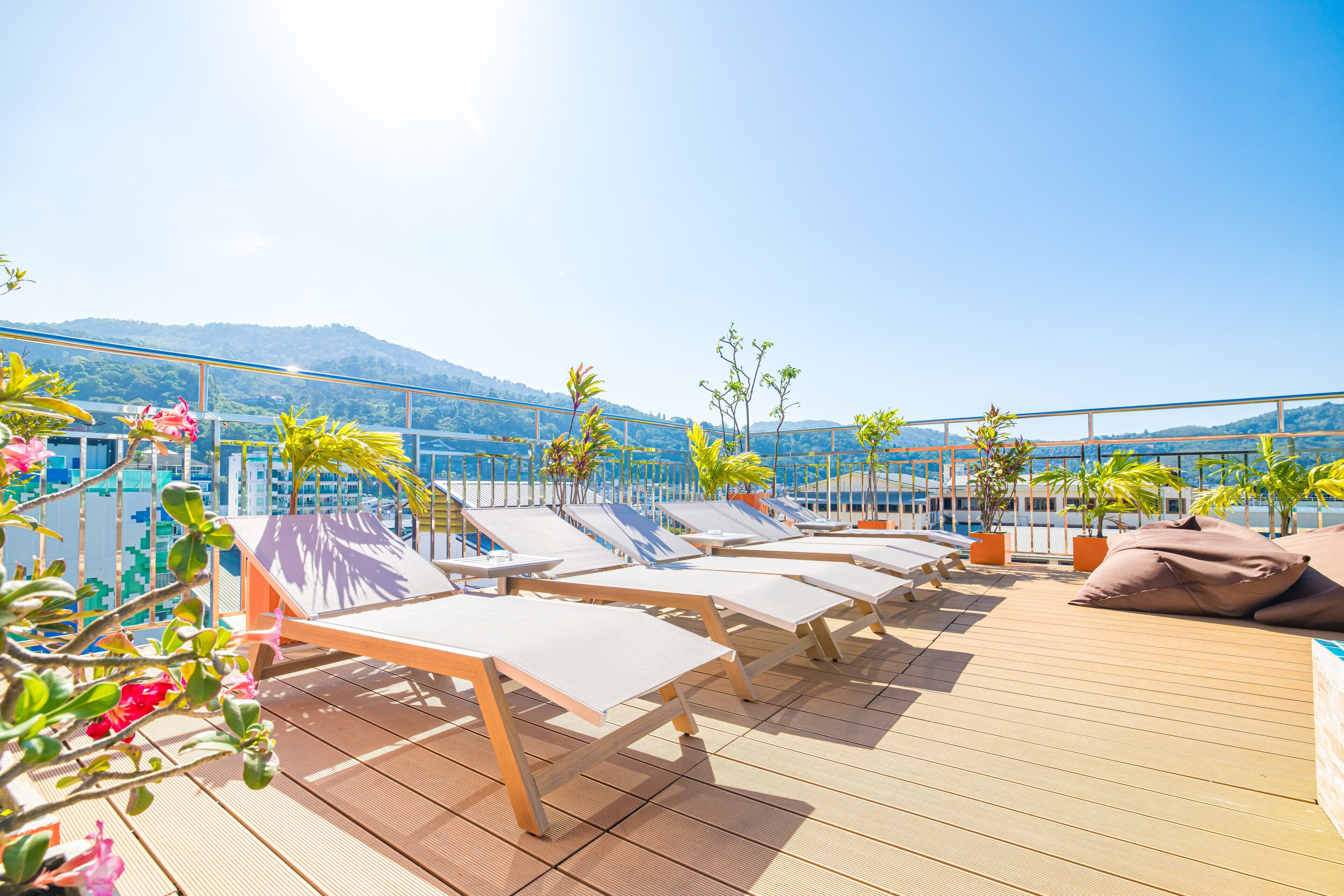 Una piscina al aire libre, sombrillas, sillones reclinables de piscina