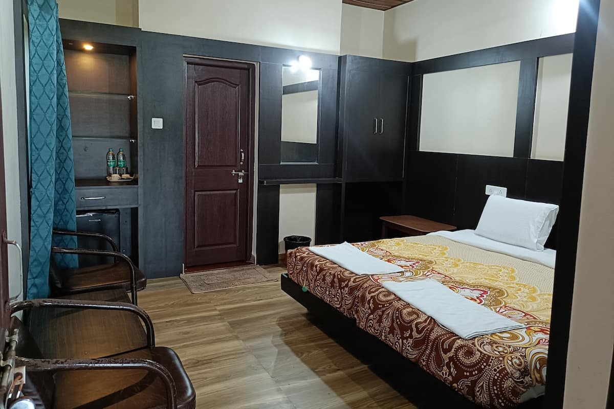 Une chambre à coucher avec un lit, un bureau, une chaise et une armoire.
