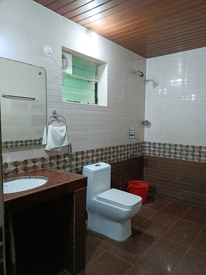 Un baño con lavamanos, inodoro y ducha.