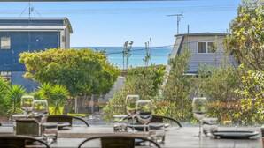 Un restaurante frente al mar con terraza, con vistas al océano y edificios residenciales.