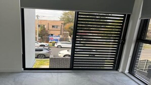 A modern room with a sliding glass door leading to a parking area. - Luxury Private Room For Rent (Sydney)