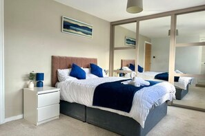 A bedroom with a bed, nightstands, a mirror, and a painting on the wall. - 4Bed 2Bath Luxe + Home Cinema (Edinburgh)