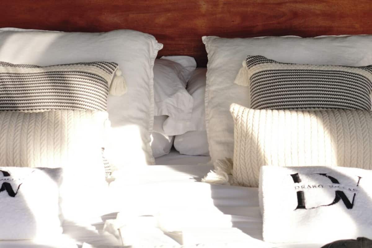 A hotel room with a bed, pillows, and a window with a view of the outside.