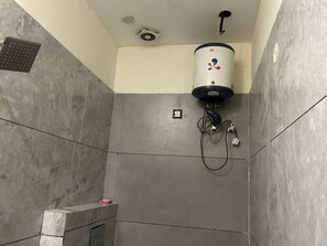 A shower area with a water heater, a vent, and a tiled wall. - Hotel Moon Regency (Panipat)