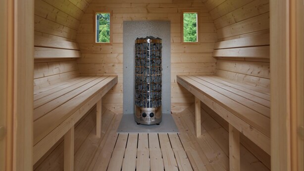 En sauna med træbænke og en central stensamle.