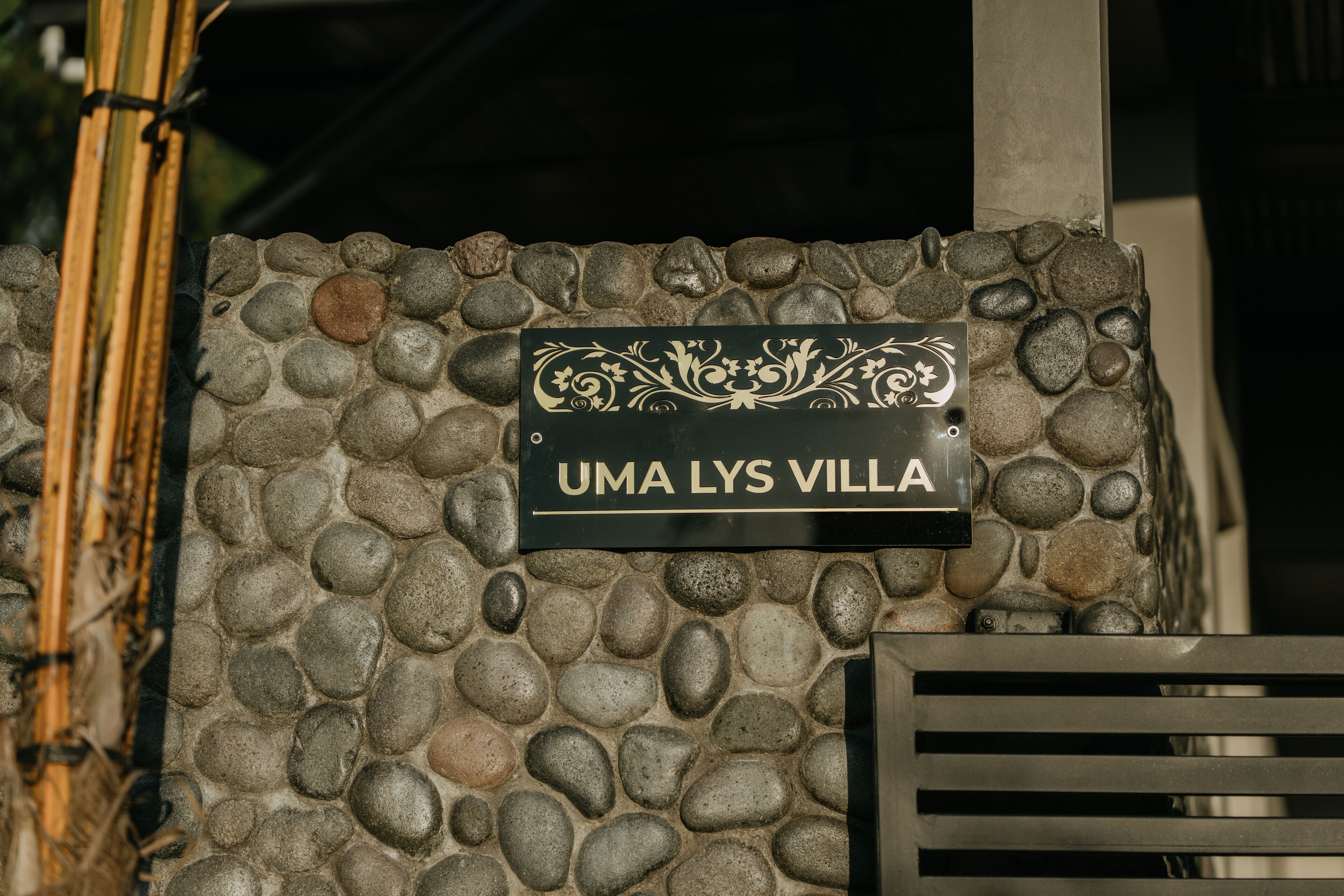 A stone wall with a sign reading "UMA LYS VILLA".