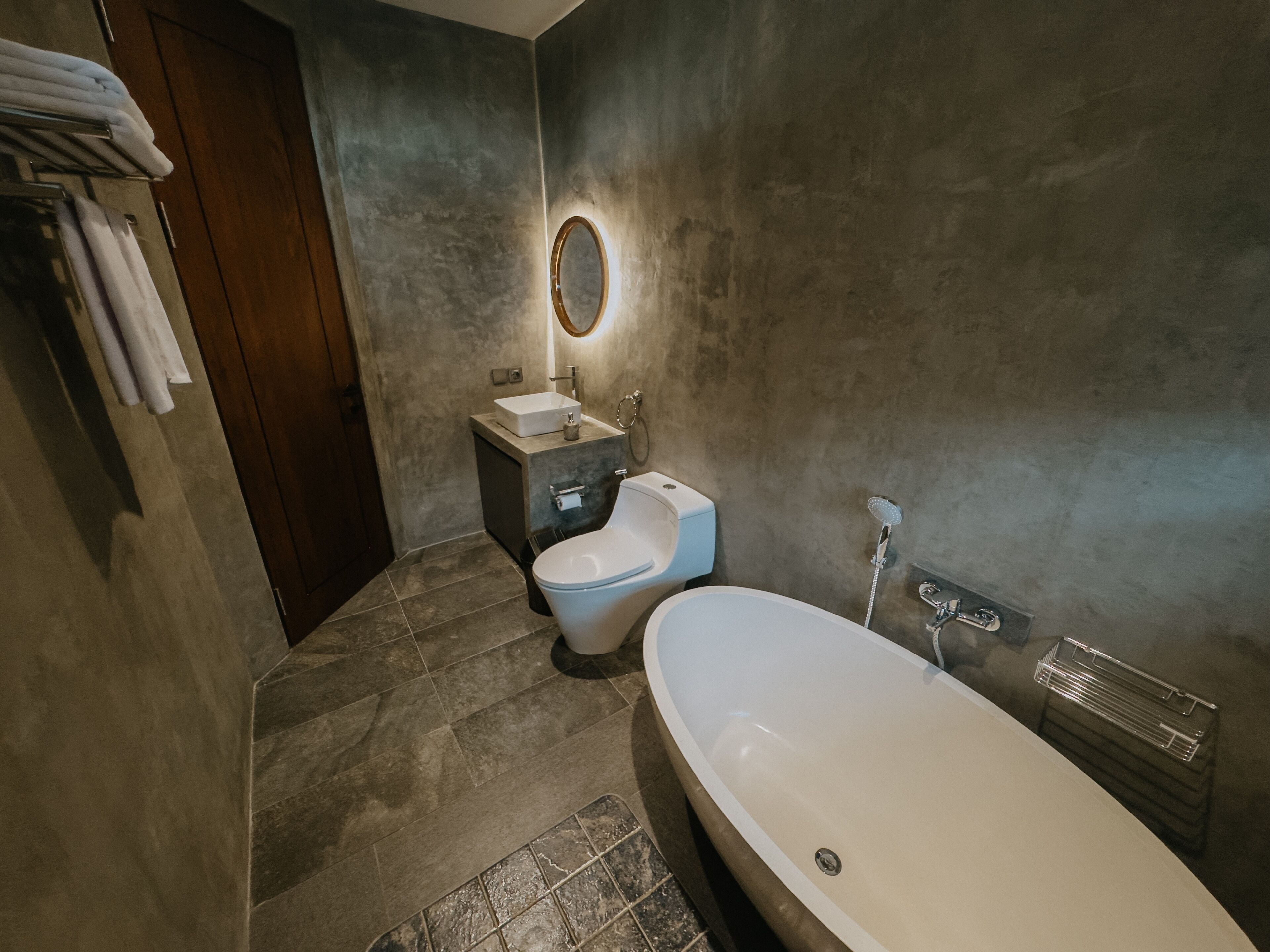 A modern bathroom with a freestanding bathtub, a toilet, and a sink.