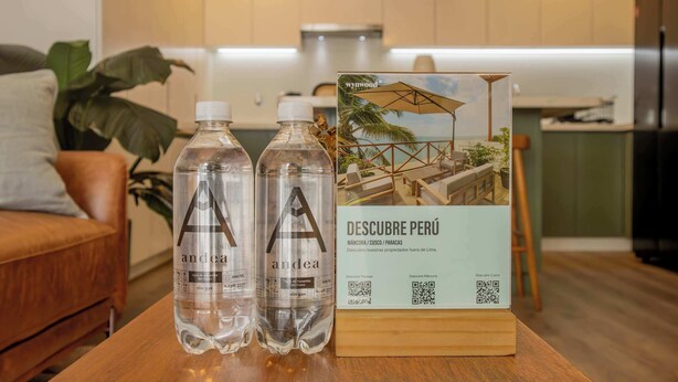 Two bottles of water, a wooden table, and a brochure titled 'Descubre Perú' on the table. - w Stunning 1BR in Miraflores (Lima)