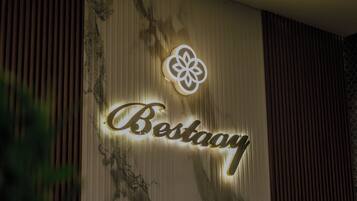 Una pared con un letrero que dice "Bestay" iluminada por luces.