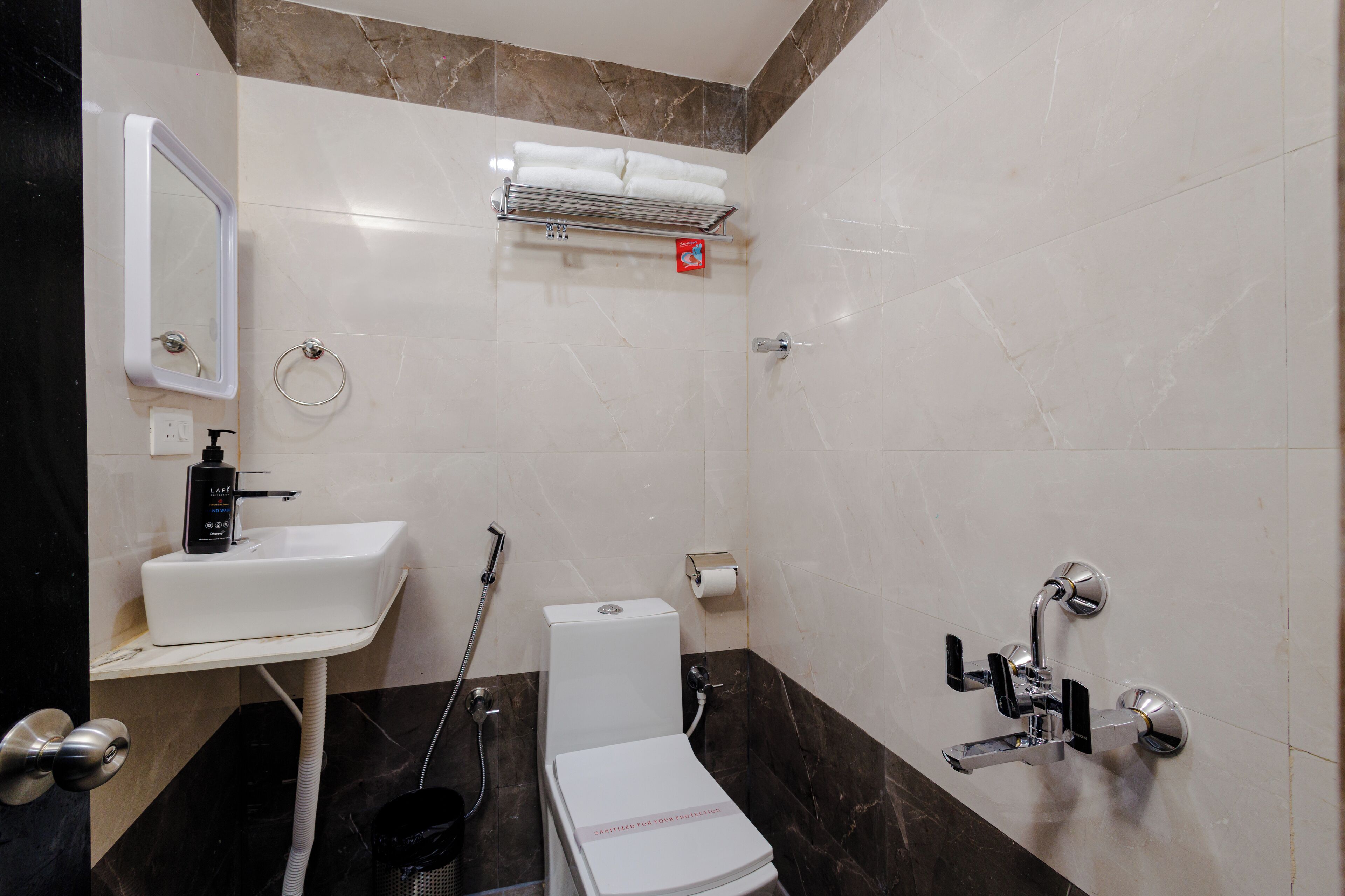 A bathroom with a white sink, a toilet, a shower, and a towel rack.