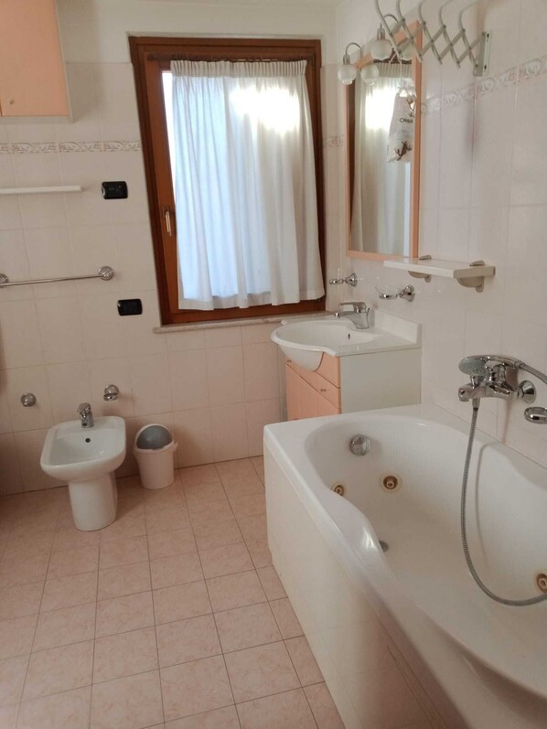 A bathroom with a bathtub, a sink, and a bidet.