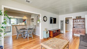 A spacious living area with a dining table and chairs, a television, and a bookshelf. - < 1 Mi to Oakland A's Park: West Sacramento Home (West Sacramento)
