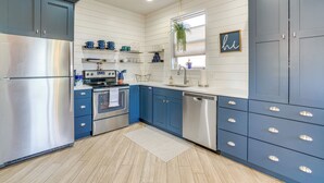 A modern kitchen with blue cabinets, stainless steel appliances, and a window with a hanging plant. - 8 Mi to Copper Mtn: Frisco Home w/ Shuttle Access (Frisco)