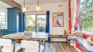 A dining area with a wooden table, white upholstered chairs, a blue cabinet, and a bench with cushions. - 8 Mi to Copper Mtn: Frisco Home w/ Shuttle Access (Frisco)