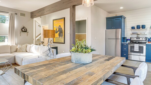 A modern kitchen with blue cabinets, a large wooden table, and a dining area with white chairs. - 8 Mi to Copper Mtn: Frisco Home w/ Shuttle Access (Frisco)