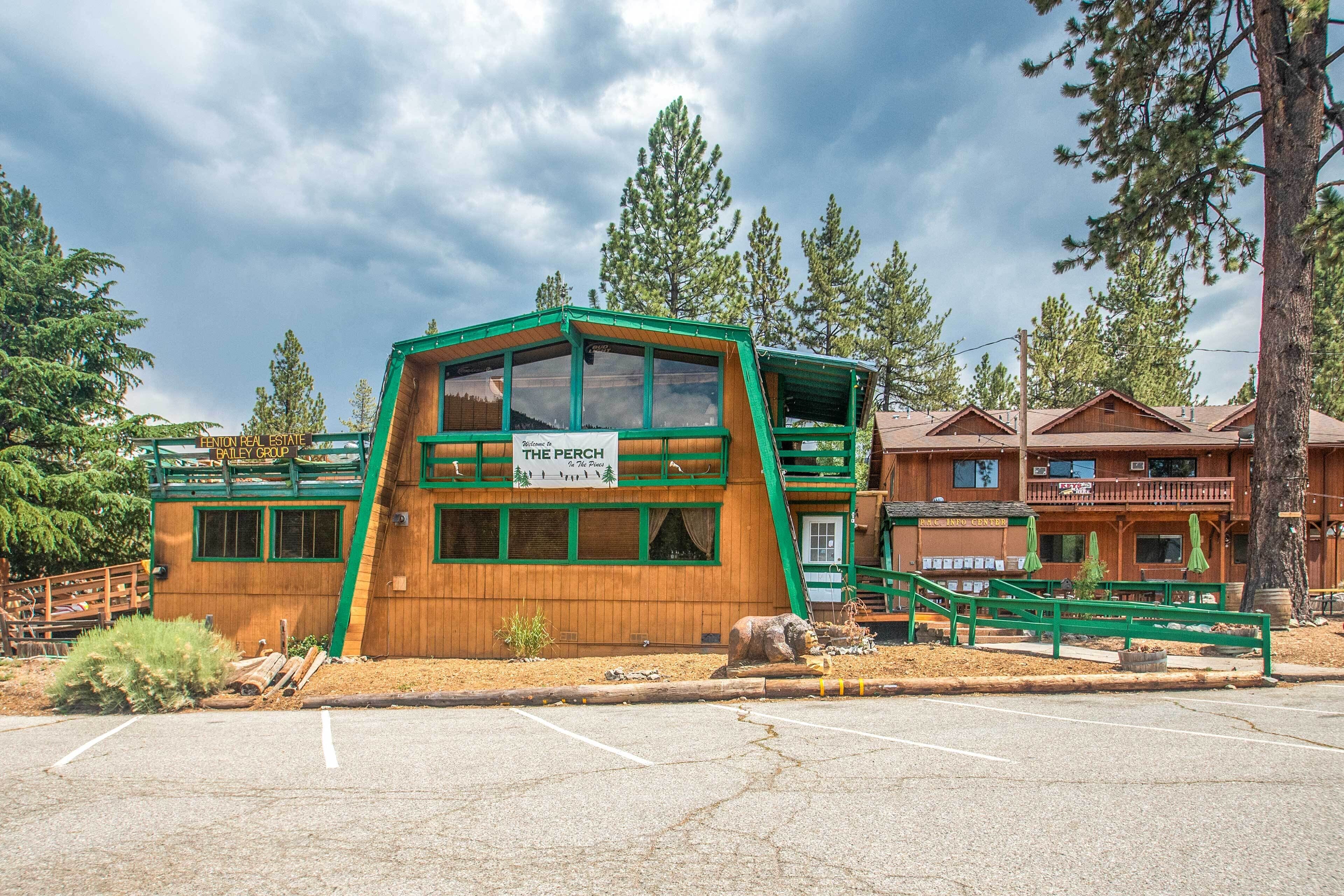 A wooden building with a green roof and a sign reading "The Perch."