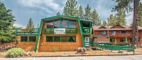 A wooden building with a green roof and a sign reading "The Perch."