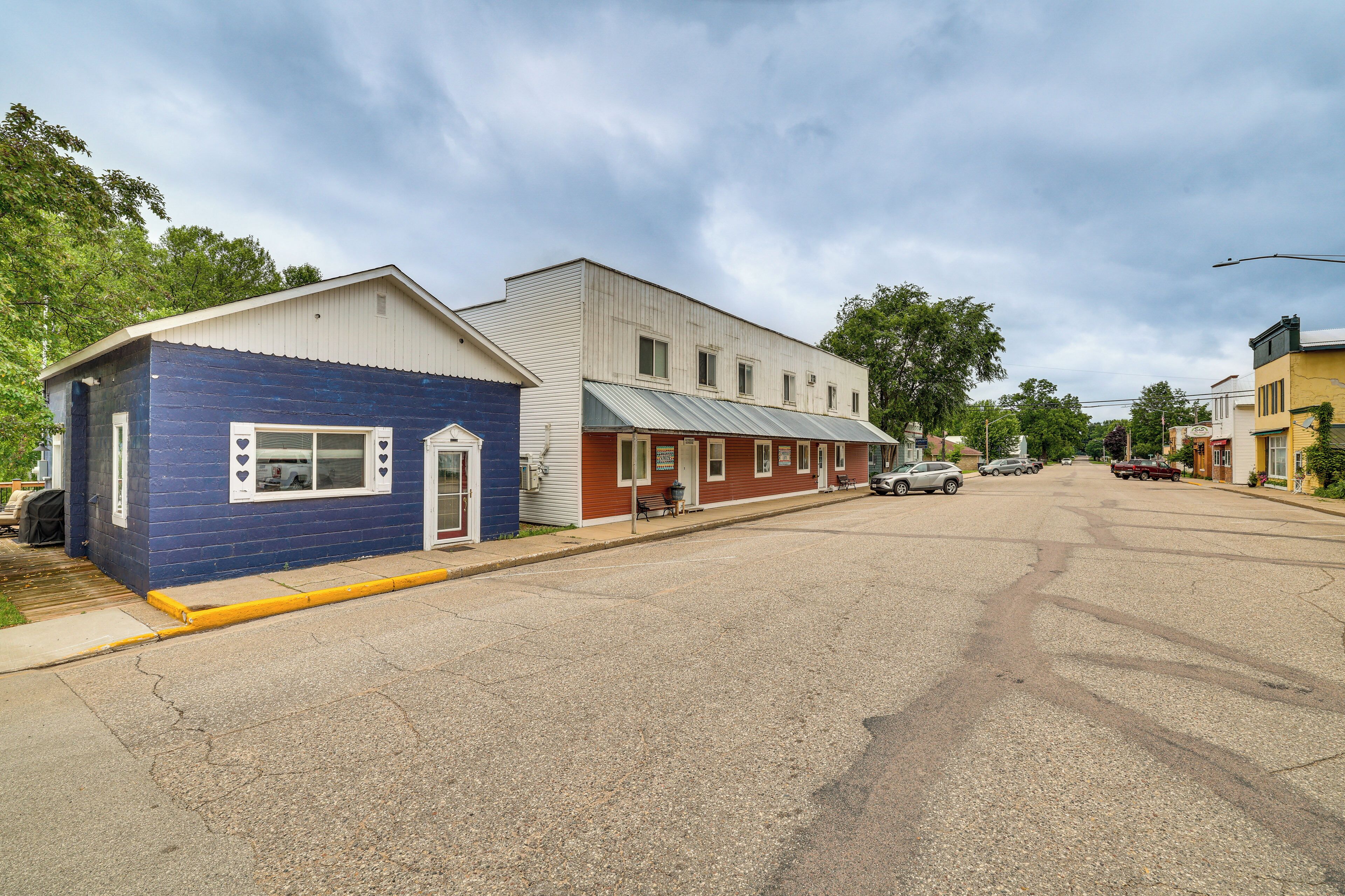 Straßenansicht mit einem blauen und einem roten Gebäude, an dem ein Schild angebracht ist.